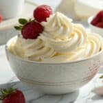 Krem z mascarpone w misce z owocami w jasnej aranżacji na marmurowym blacie