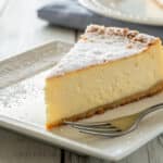 Sernik puszysty i wilgotny z gładką powierzchnią i wilgotnym środkiem na białym talerzu