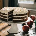 Domowe ciasto do szkoły pokrojone na kawałki obok śniadaniówki i świeżych owoców