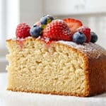 Szybkie ciasto bezglutenowe z truskawkami i cukrem pudrem na jasnym blacie kuchennym